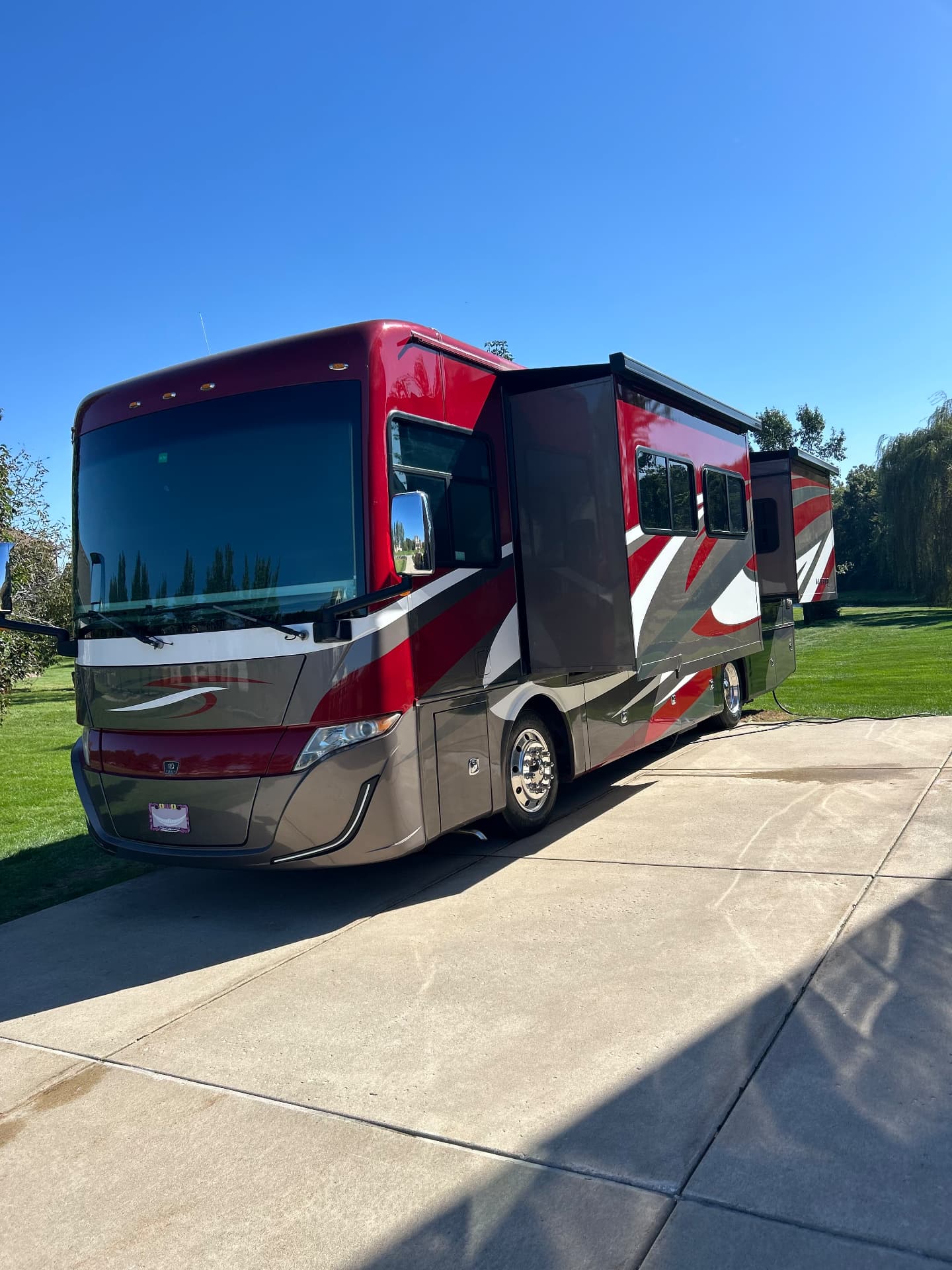 Red and silver motorhome parked in a driveway