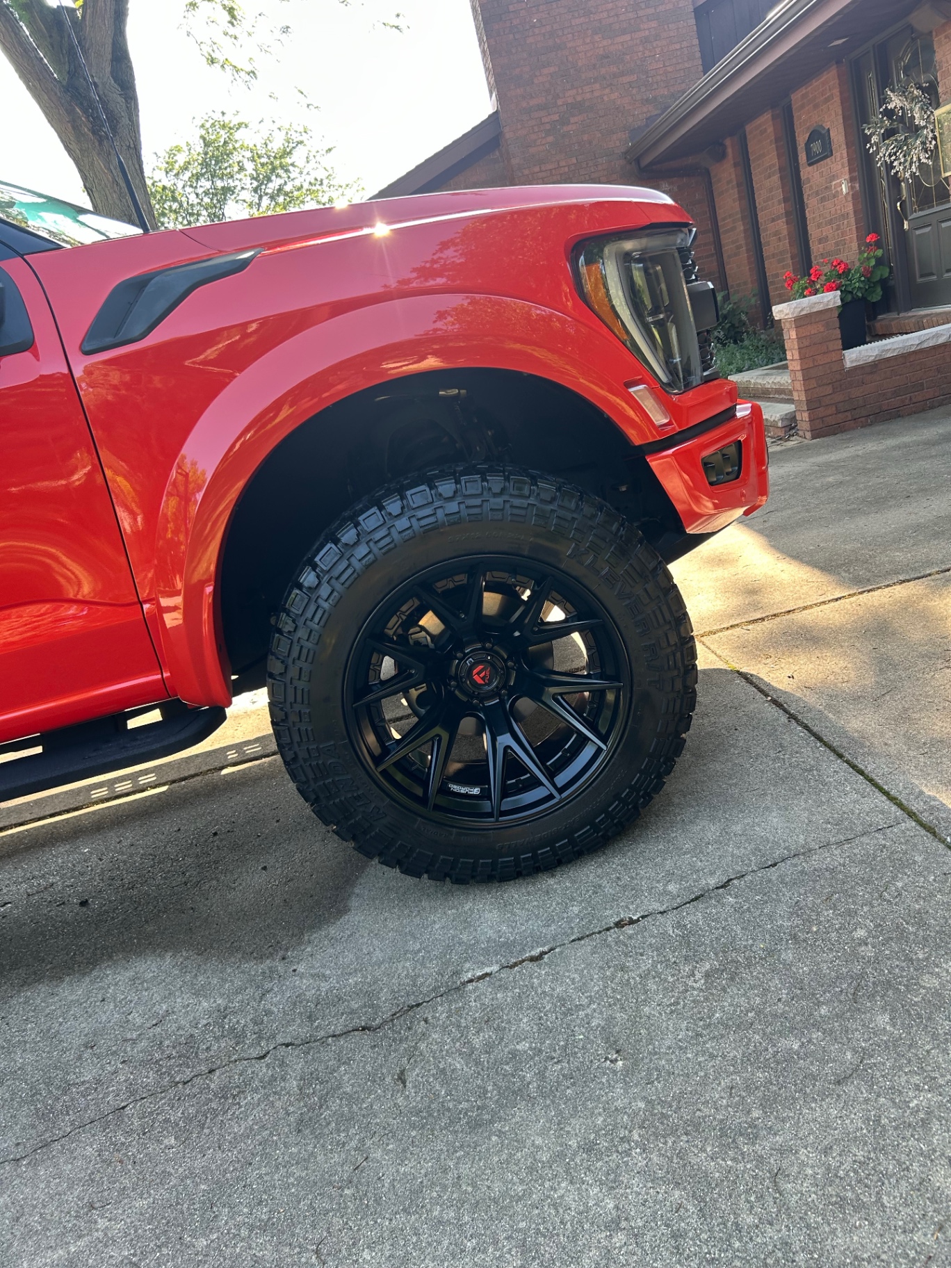 Red lifted Ford F-150 with detailed wheels and tires