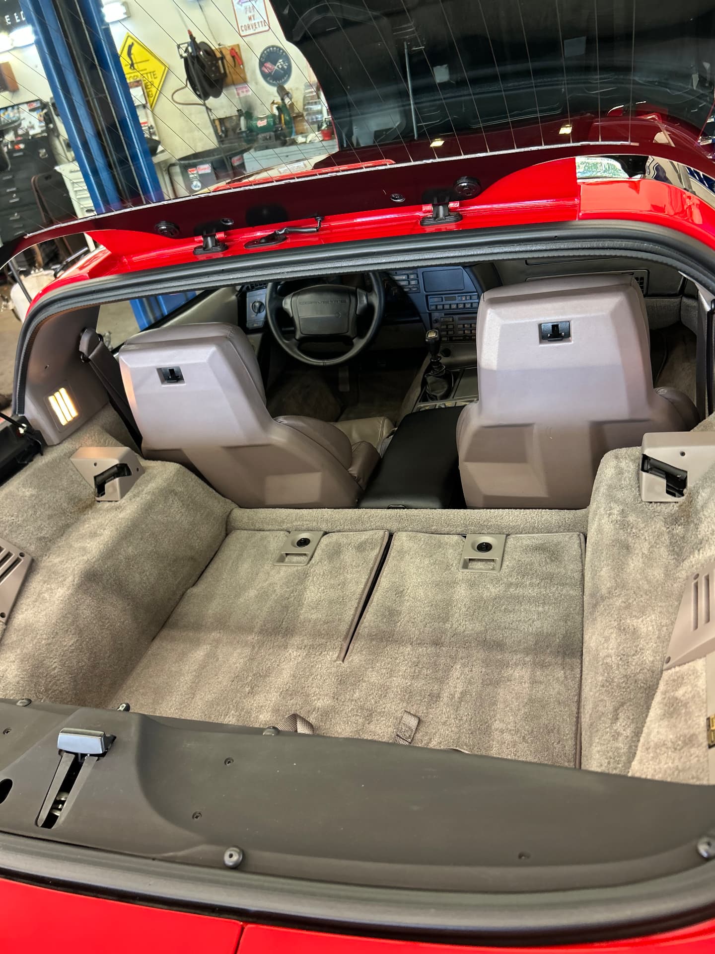 Red Corvette rear cargo area with clean beige carpeting